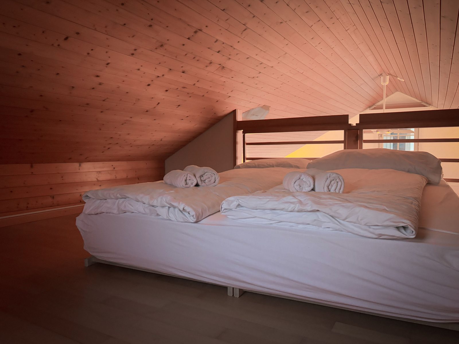 Warm loft bedroom with timber-clad ceiling after a dormer conversion
